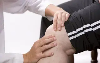 Physical Therapist checks knee